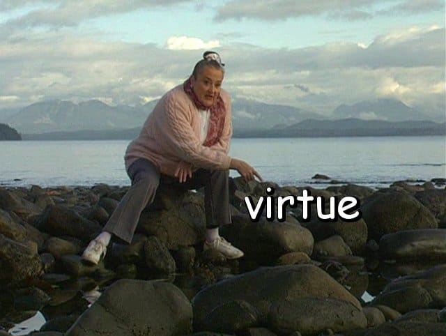 the word "virtue" with Marie on the beach rocks