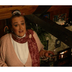 Marie Rackham looking up the stairs in her cozy beach cottage.