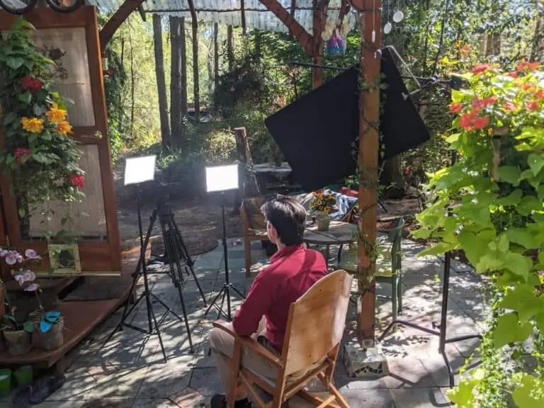 Thomas in Marie's rocking chair on the patio in front of his cozy writing yurt